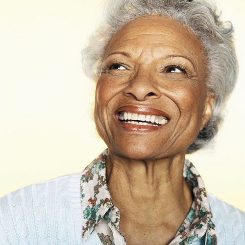 Woman smiling after getting new dental implants to replace her missing teeth at Solutions Dental Implants in Sun City West, AZ.