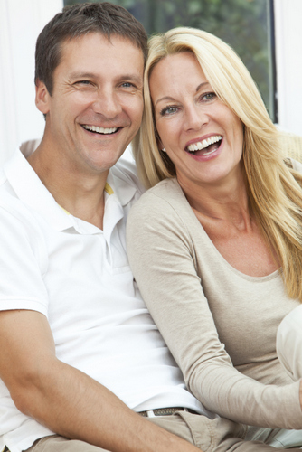 Smiling couple with dental implants from Solutions Dental Implants in Sun City West, AZ