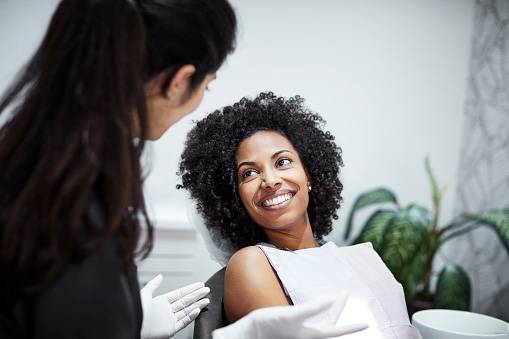Woman talking to dentist about tooth loss at Solutions Dental Implants in Sun City West, AZ Woman talking to dentist about tooth loss at Solutions Dental Implants in Sun City West, AZ
