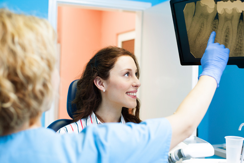 a patient being shown her iCAT 3Dd imaging results at Solutions Dental Implants 